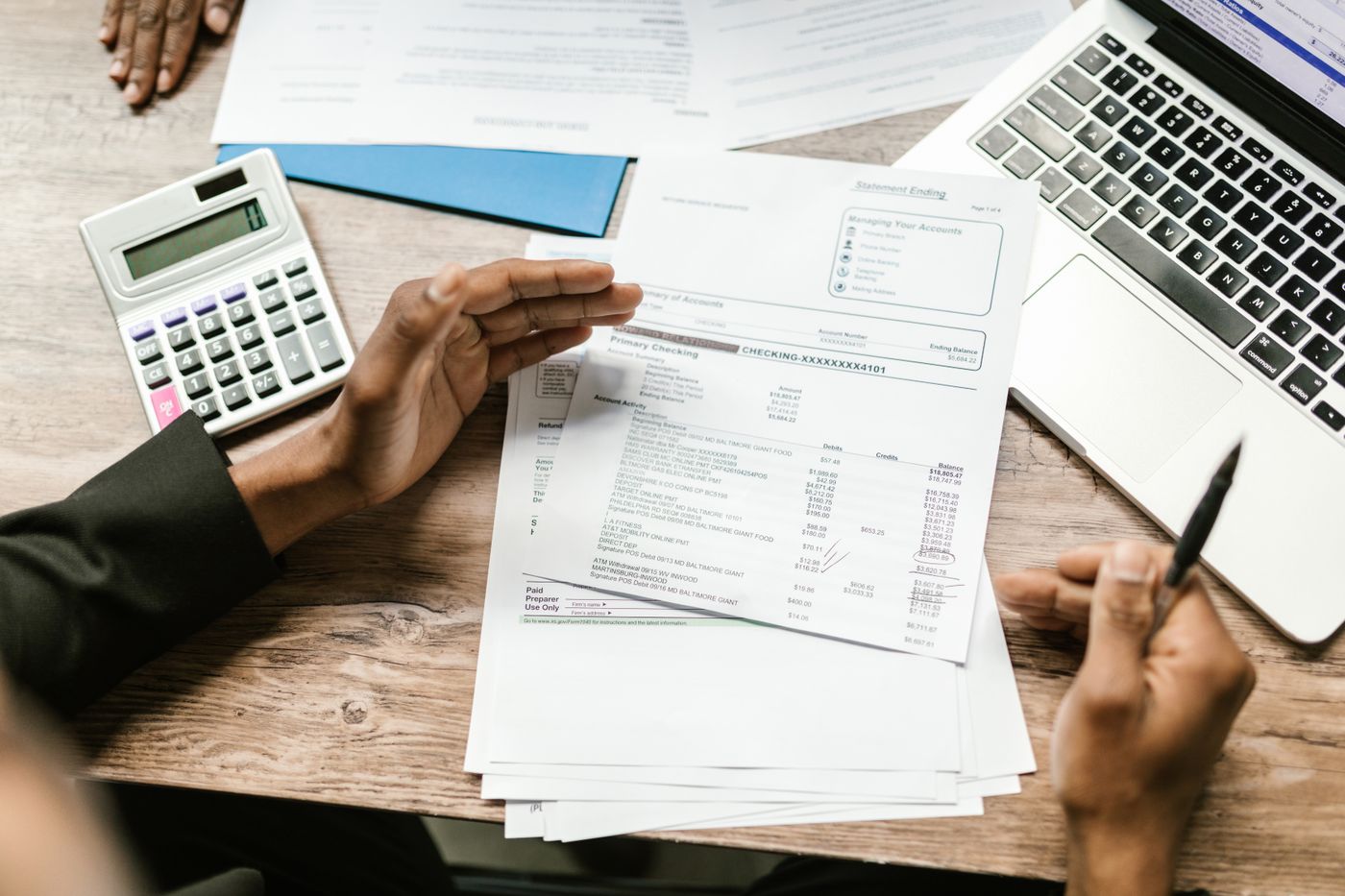 Documentos, facturas y calculadora sobre un escritorio, en revisión durante la fiscalización mensual